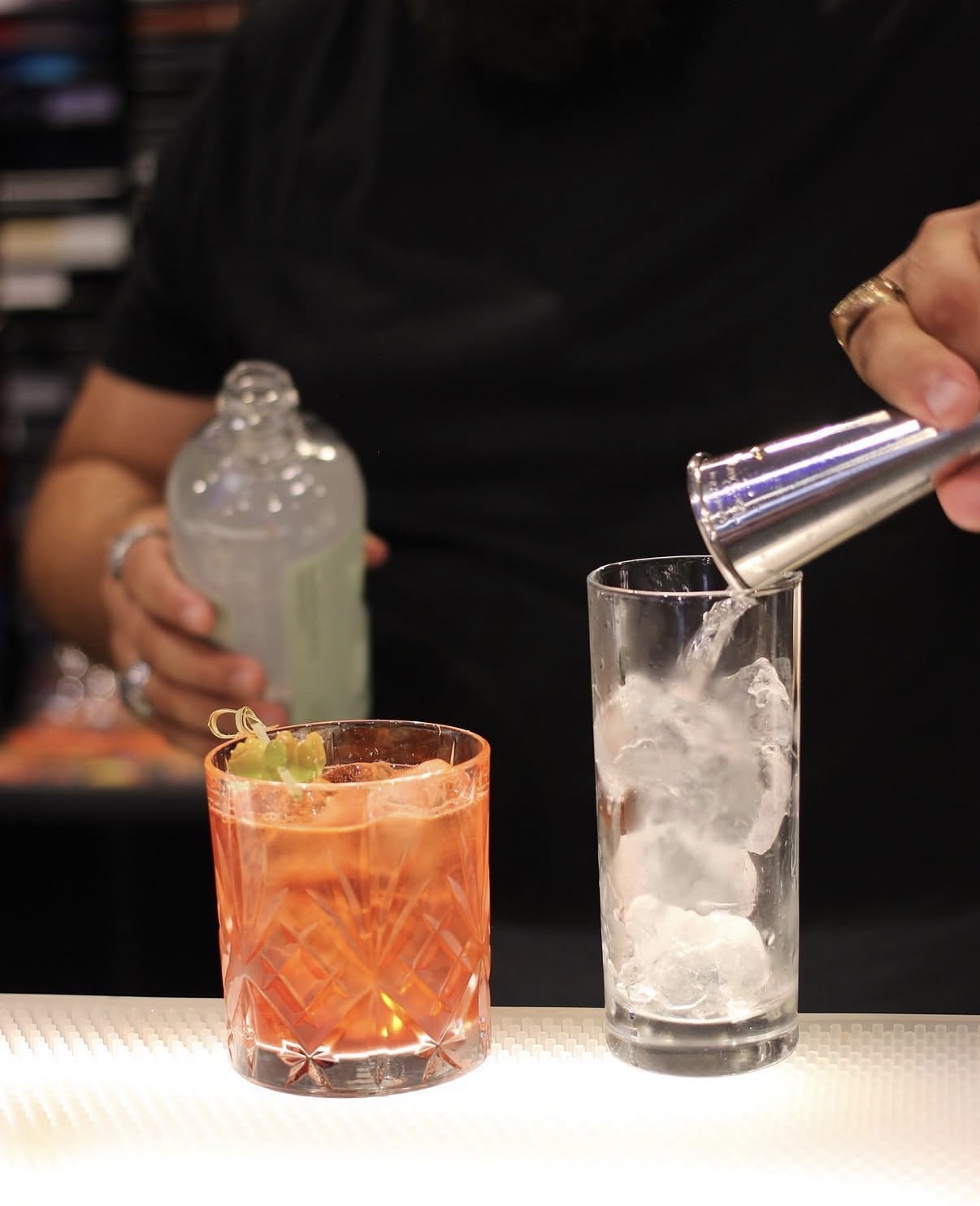 Bartender versa un cocktail nei due drink al bancone